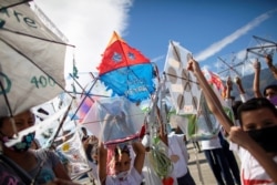 Niños sostienen cometas en el barrio Petare que celebra 400 años de su fundación, en Caracas.