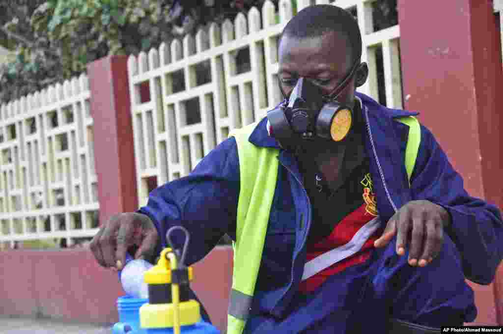 An employee of the Monrovia City Corporation mixes disinfectant before spraying it on the streets to prevent the spread of the deadly Ebola virus, Monrovia, Liberia, August 1, 2014. 