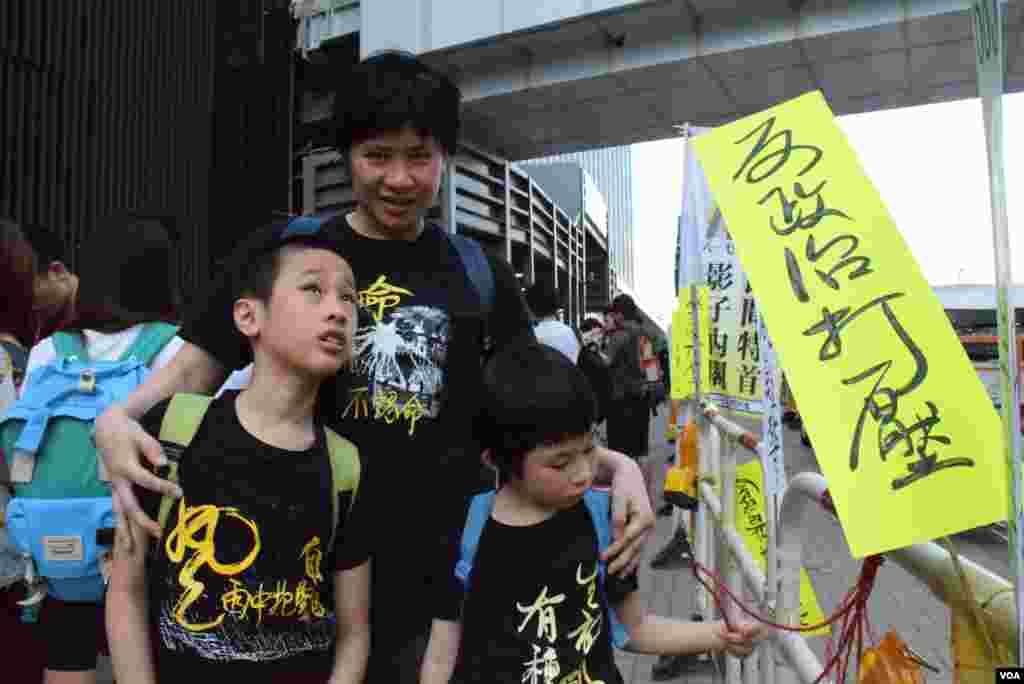 香港市民劉太太帶同一對9歲及7歲的子女參與雨傘運動一周年活動。 (美國之音特約記者湯惠芸照)