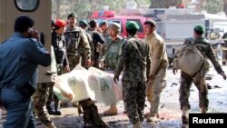 Afghan National Army (ANA) soldiers transport a victim to an ambulance after a suicide attack in Lashkar Gah, Helmand province, Afghanistan, Feb. 11, 2017.