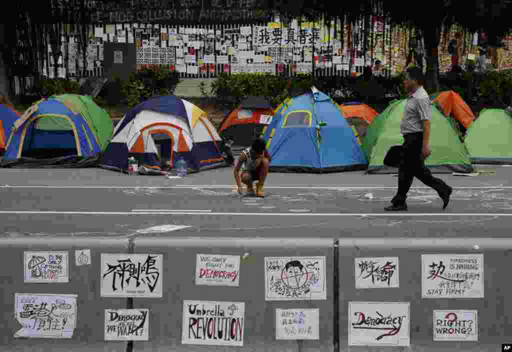 A protester draws on a main road in the occupied areas outside government headquarters, in Hong Kong's Admiralty, Oct. 10, 2014.