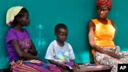 People suspected of Ebola infection await treatment outside a hospital near Monrovia, Liberia, Oct. 24, 2014. More than 10,000 people have the virus, the World Health Organization reported. 
