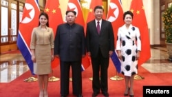 中国国家主席习近平和夫人彭丽媛在北京人大会堂同朝鲜国务委员会委员长金正恩和夫人李雪主合影。（2018年3月28日）