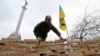 A man stacks wooden bars showing names of Ukrainian cities and settlements that are hometowns of demonstrators, during a rally in Independence Square in Kyiv, Dec. 16, 2013. 