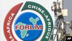 资料照片：一名中国男子在北京天安门广场中非合作论坛标志附近修理安全摄像头。（2006年10月29日）