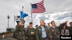 Menteri Pertahanan Korea Selatan Kim Kwan-jin (kanan) menunjukkan arah wilayah Korea Utara kepada Menhan AS Chuck Hagel saat meninjau Zona Demiliterirasi (DMZ) yang memisahkan kedua Korea, Senin (30/9).