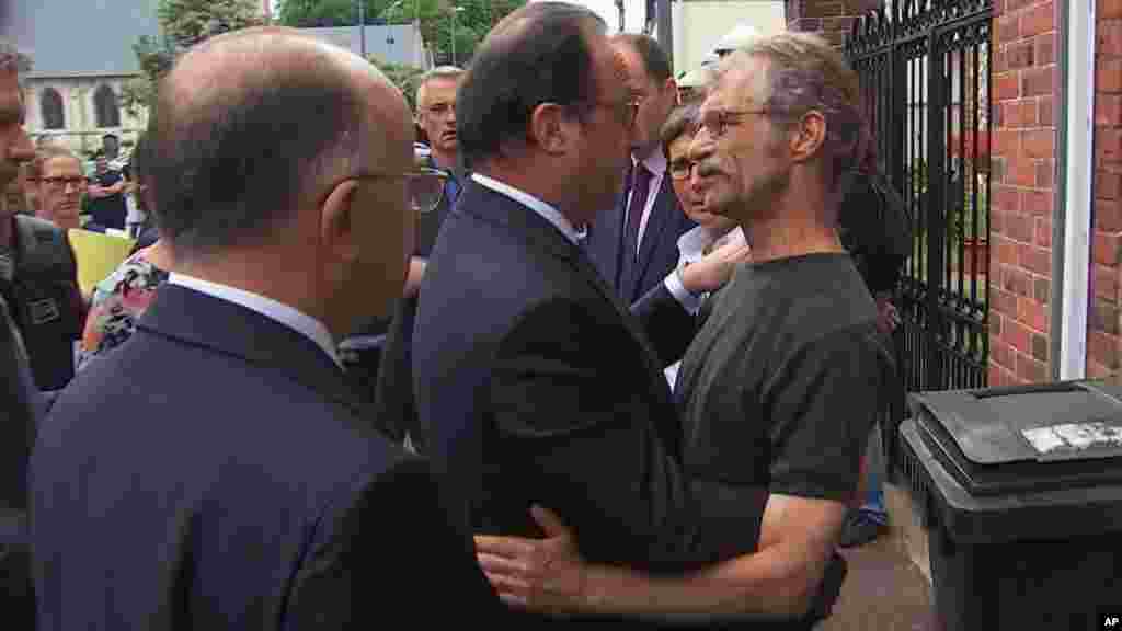 François Hollande, qui s'est rendu sur les lieux, s'entretient avec le maire de la commune normande, Hubert Wulfranc, peu après le drame, le 26 juillet 2016.