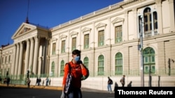 Un hombre llevando alimentos camina frente al Palacio Nacional en San Salvador, El Salvador, el 22 de marzo de 2020.