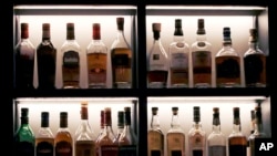 FILE - A vast array of fine single malt Scotch whiskey bottles are seen in a display case at a bar, in Boston, Massachusetts, Dec. 10, 2019. One hundred years ago, the U.S. tried but failed out outlaw alcohol.