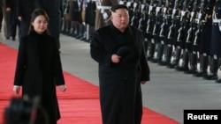 North Korean leader Kim Jong Un and wife Ri Sol Ju inspect an honor guard before leaving Pyongyang for a visit to China, in this Jan. 7, 2019 photo released by North Korea's Korean Central News Agency (KCNA) in Pyongyang, Jan. 8, 2019. 