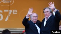 FILE - Actor Gerard Depardieu (R) and then-FIFA President Sepp Blatter pose on the red carpet for the screening of the film "United Passions" at the 67th Cannes Film Festival, May 18, 2014.