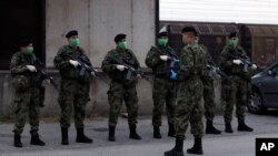 Tentara Serbia berpatroli di sekitar pusat pengungsi, di Sid, sekitar 100 km barat dari Beograd, Serbia, Sabtu, 16 Mei 2020. (Foto: AP)