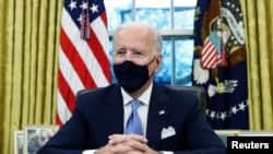  U.S. President Joe Biden signs executive orders in the Oval Office of the White House in Washington, after his inauguration as the 46th President of the United States, Jan. 20, 2021.