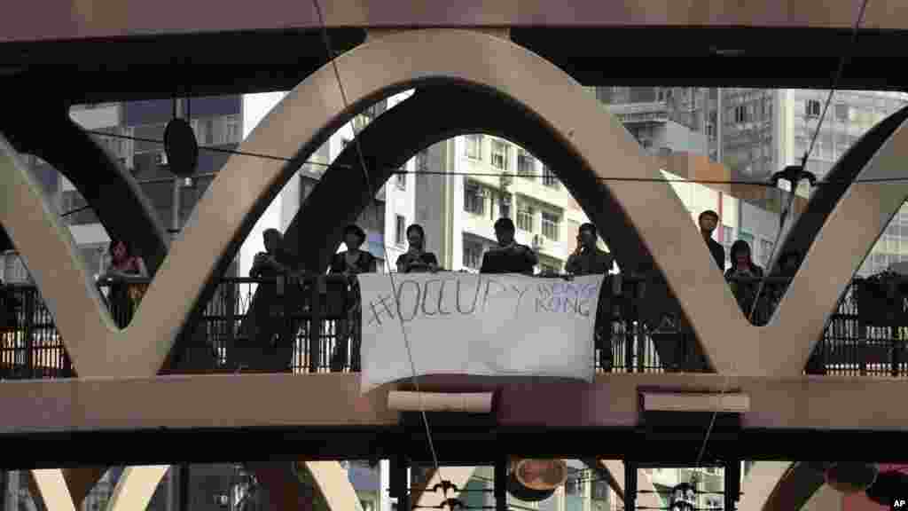 A banner calling to "occupy Hong Kong" hangs from a pedestrian overpass above a sit-in protest in Hong Kong, Sept. 29, 2014.
