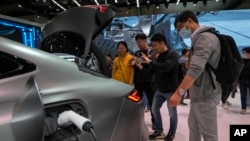 参观者在北京举行的2024中国国际车展上观看中国制造的吉利Galaxy E8电动汽车车型。(2024年4月28日)