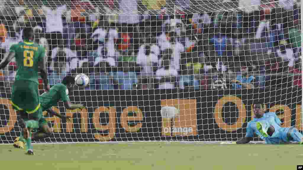 Mame Birame Diouf du Sénégal, deuxième à gauche, marque un but contre le gardien du Ghana Razak Braimah, à droite, lors du match de football de la Coupe d'Afrique des Nations, Groupe C, entre le Ghana et le Sénégal à Mongomo, la Guinée équatoriale, lundi 19 janvier 2015.