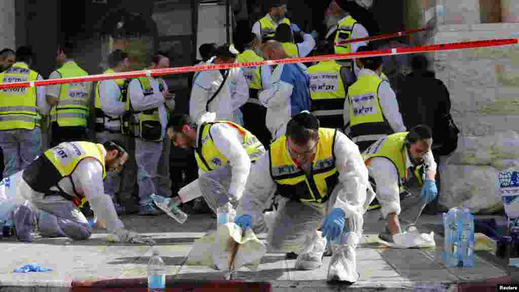 Members of the Israeli Zaka emergency response team clean blood from the scene of an attack at a Jerusalem synagogue, Nov. 18, 2014.