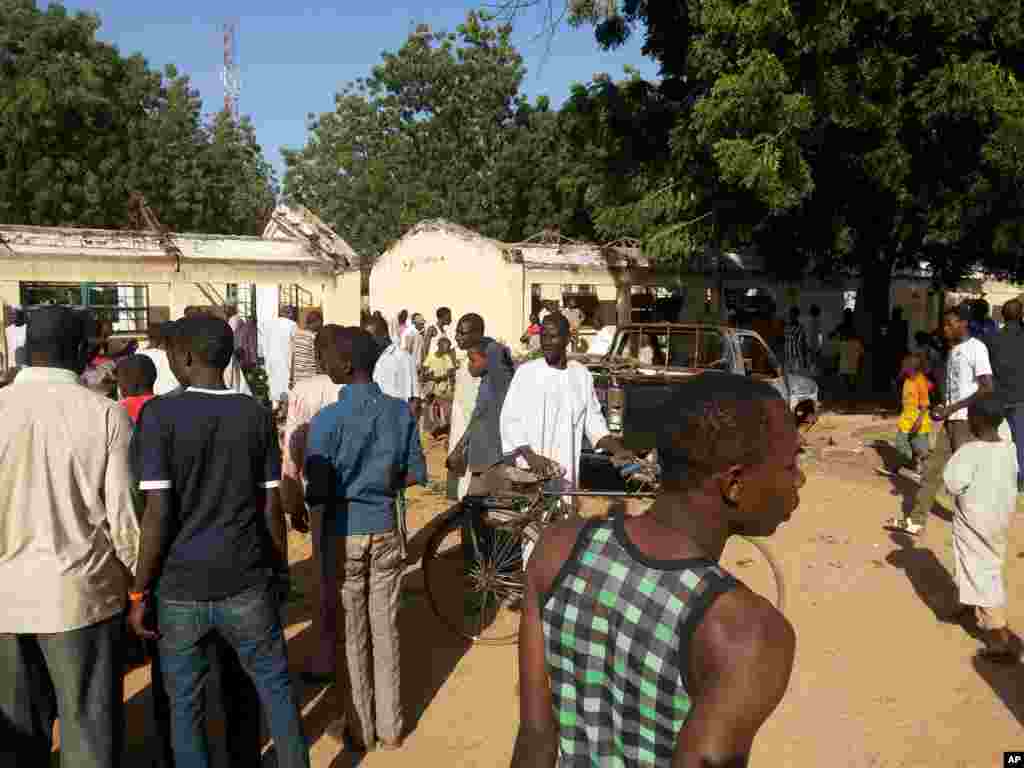 People inspect the damaged roof at the site of a suicide bomb explosion at the Government Science Technical College in Potiskum, Nigeria, Nov. 10, 2014.