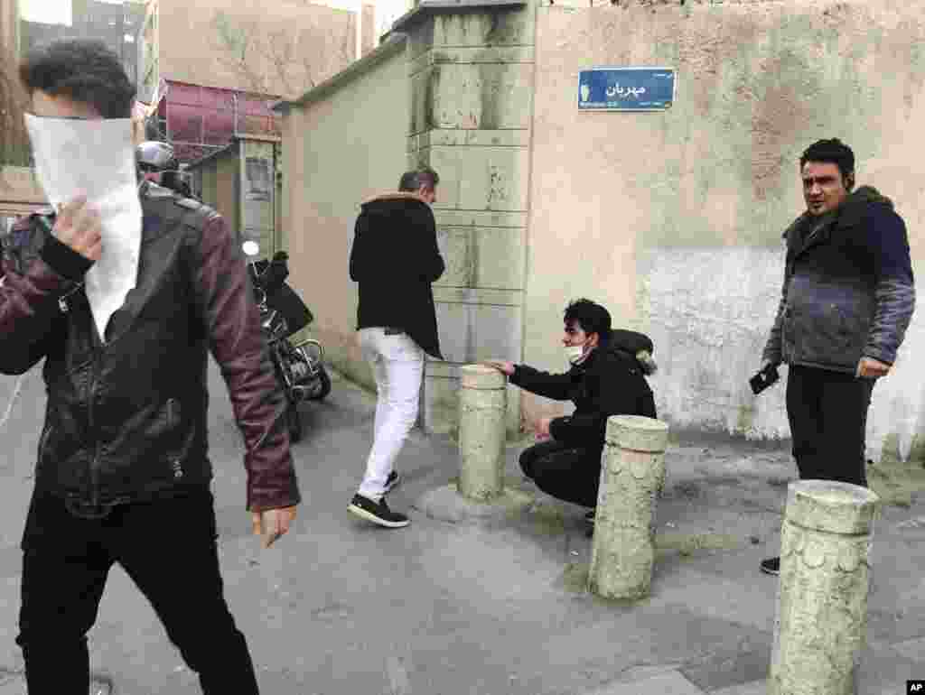 In this photo taken by an individual not employed by the Associated Press and obtained by the AP outside of Iran, people are affected by tear gas fired by anti-riot Iranian police to disperse demonstrators in a protest over Iran's weak economy, in Tehran, Iran, Dec. 30, 2017.