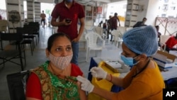 Una mujer es inoculada contra COVID-19 en un centro de vacunación en Ahmedabad, India, el 30 de julio de 2021.