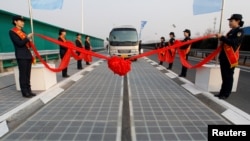 Un véhicule est vu sur une autoroute à panneaux solaires lors de son inauguration à Jinan, dans la province du Shandong, en Chine, le 28 janvier 2017