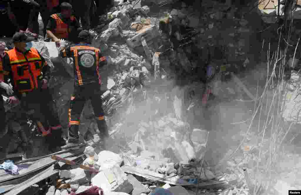 Los rescatistas palestinos recuperan el cuerpo de una víctima entre los escombros en el lugar de los ataques aéreos israelíes, en la ciudad de Gaza.