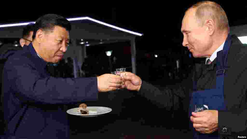 Shugaban kasar Rasha Vladimir Putin da na kasar China Xi Jinping, na gaisawa a lokacin ziyarar sa lokacin babban taron tattalin arziki a kasar Rasha. 