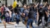 Demonstran anti vaksin (kiri) terlibat pertikaian dengan orang-orang yang berlawanan pendapat dengan mereka dalam sebuah unjuk rasa anti vaksin di depan Balai Kota Los Angeles, AS, pada 14 Agustus 2021. (Foto: AP/Damian Dovarganes)