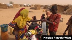 Des enfants autour de la pompe à eau dans le camp de réfugiés d'Assaga, Diffa, Niger, le 17 avril 2017 (VOA/Nicolas Pinault)