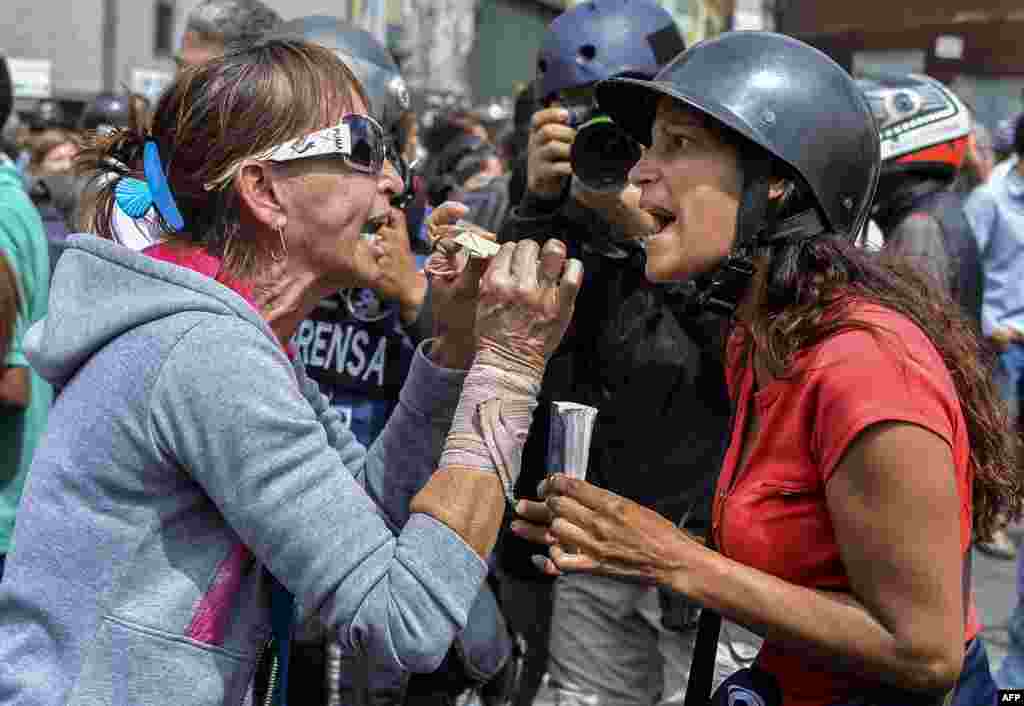 Backers of the government of Venezuela's President Nicolas Maduro (L) and opposition activists face off in front of the Supreme Court of Justice in Caracas.