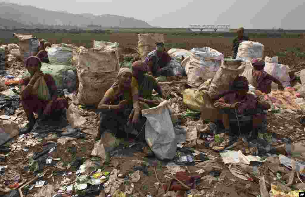 Indian ragpicker women rest after searching for recyclable material at a garbage dumping site on International Women's Day in Gauhati, March 8, 2017.