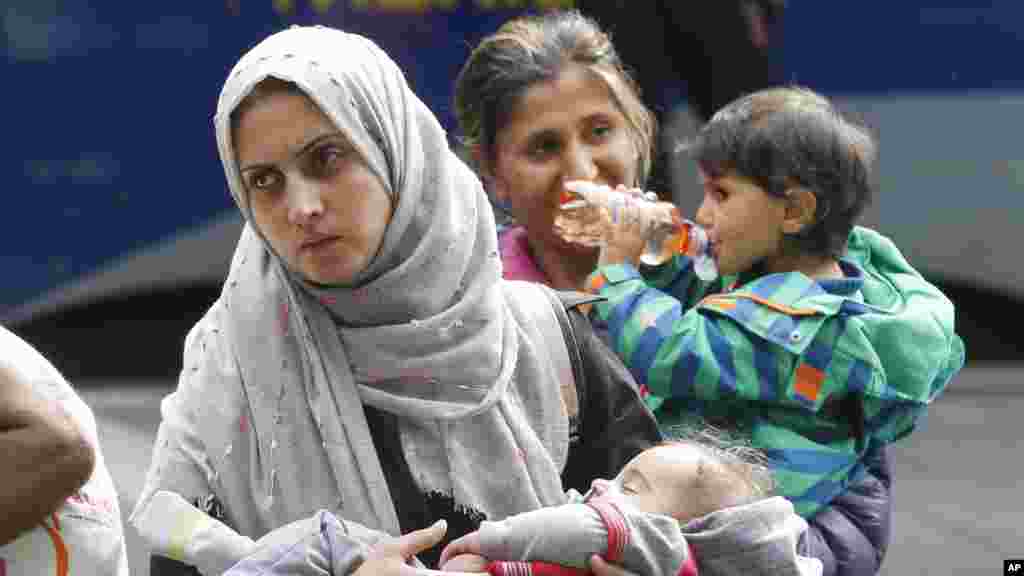 Une femme porte un enfant à leur arrivée à la gare principale de Munich, en Allemagne, 5 septembre 2015.
