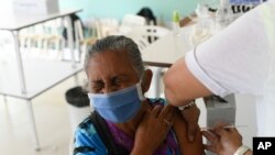 Una mujer cierra los ojos mientras recibe una inyección de la vacuna cubana contra el COVID-19 Abdala en el complejo Ciudad Tiuna de Caracas, el 29 de junio de 2021.