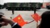 FILE - Onlookers wave Chinese flags as military vehicles carrying DF-41 ballistic missiles roll during a parade in Beijing, China, Oct. 1, 2019.