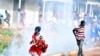 Des partisans de Bobi Wine fuient les gaz lacrymogènes lors d'un rassemblement de campagne près de Kampala, en Ouganda, le 30 novembre 2020.