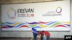 Les femmes passent à côté d'une affiche annonçant le prochain sommet de la Francophonie à Erevan, le 6 octobre 2018.