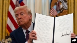 Predsjednik Donald Trump drži izvršnu naredbu u Washingtonu, 23. januara 2025. Otkako je preuzeo dužnost, Trump je potpisao brojne izvršne naredbe, uključujući one o povlačenju SAD-a iz Svjetske zdravstvene organizacije i Pariskog klimatskog sporazuma.