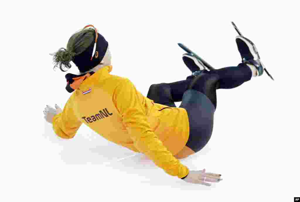 Ireen Wust of the Netherlands slides towards a team member as she celebrates winning gold in the women's 3,000-meter speedskating race at the Adler Arena Skating Center, Sochi, Russia, Feb. 9, 2014.