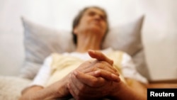 FILE - Alzheimer's disease patient Isidora Tomaz, 82, sits in an armchair in her house in Lisbon, Portugal, Sept.15, 2009. 