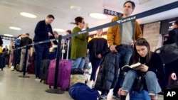 Viajeros esperan para abordar un tren en Albany, Nueva York, mientras las tormentas de nieve azotan gran parte de EE.UU. el 27 de noviembre de 2019.