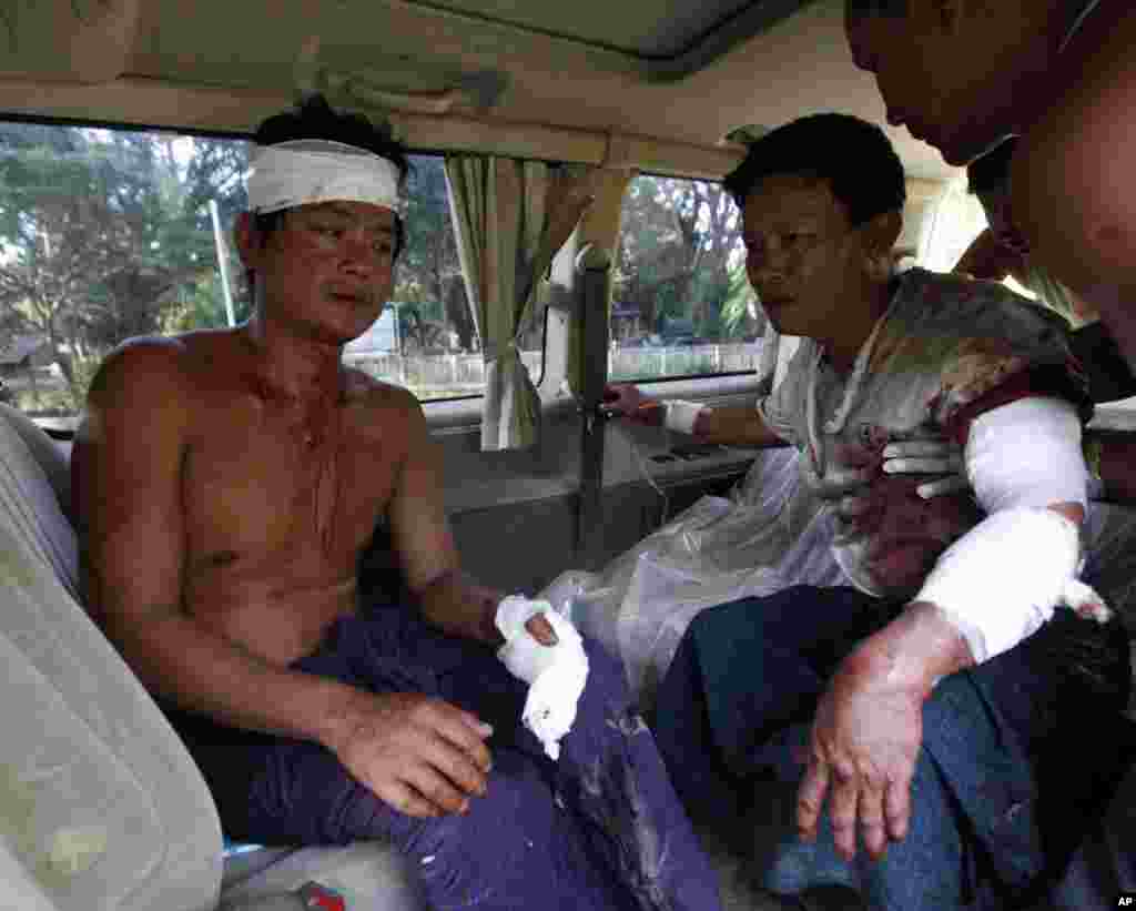 Two injured Rakhine men sit in a car as they prepare to go to hospital in Thandwe, Rakhine State, western Burma, Oct. 1, 2013.