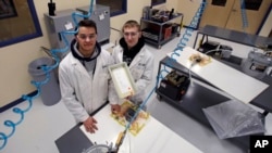FILE - High School students P.J. Perkins, left, and Dylan DiBernardo in a manufacturing lab at Great Bay Community College in Rochester, N.H. Jan. 4, 2019 where they study for manufacturing certificates. (AP Photo/Charles Krupa)