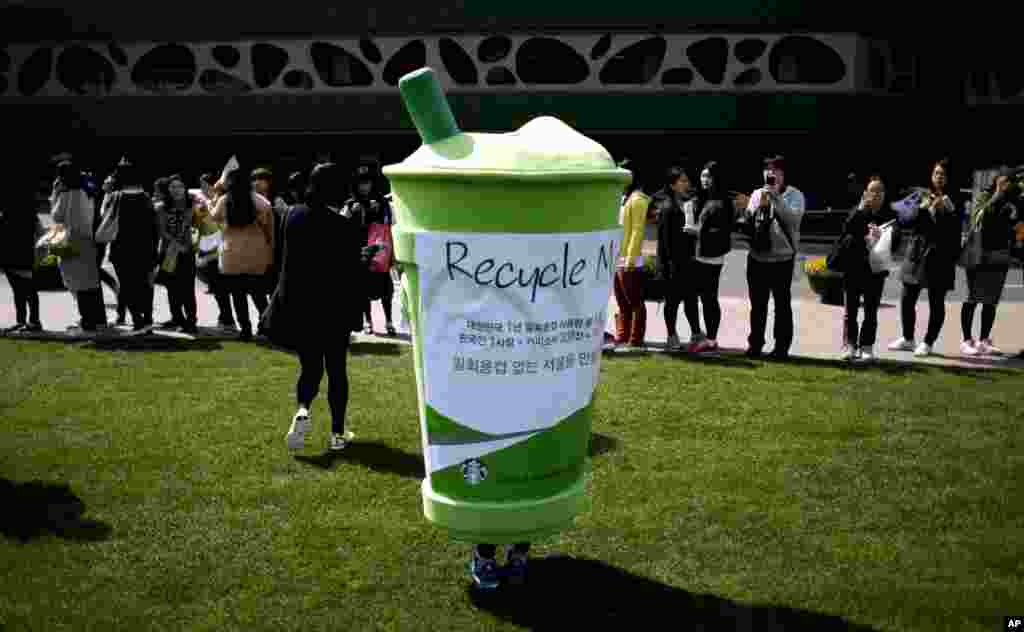 4月22日在韓國首爾的市政廳前,一名志願者把自己裝扮成一次性紙杯,參加環保人士發起的慶祝地球日活動。