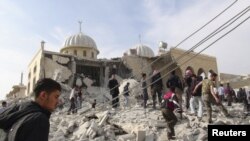 Residents and members of the Free Syrian Army inspect Bilal mosque, which activists said was damaged after it was fired upon by a Syrian Air Force fighter jet loyal to Syria's President Bashar al-Assad, at Marat al-Numan near the northern province of Idli