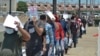 ARCHIVO - En esta fotografía de archivo del 25 de julio de 2019, agentes de la Patrulla Fronteriza de Estados Unidos devuelven a un grupo de migrantes al lado mexicano de la frontera mientras los funcionarios de inmigración mexicanos revisan la lista, en Nuevo Laredo, México.