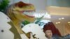 
Un garçon chinois devant un modèle de dinosaure avant sa prise de poser photo à Beijing, le 6 Août 2014.
