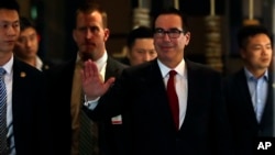 US Treasury Secretary Steven Mnuchin, center, waves to reporters as he arrives at a hotel after meeting with Chinese officials in Beijing, Thursday, May 3, 2018. (AP Photo/Andy Wong)