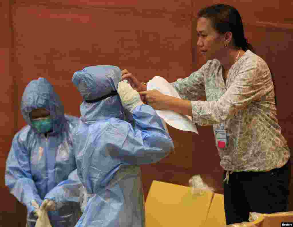 Filippin sog'liqni saqlash xodimlari Eboladan ogohlik oyligi doirasida o'tkazilayotgan mashg'ulotda himoya kiyimlaridan qanday foydalanishni o'rganmoqda, Manila, Filippin, 28-oktabr, 2014-yil