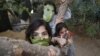 Des enfants palestiniens posent avec des masques de fortune faits avec des feuilles de chou lorsqu'ils cuisinent à la maison avec leur famille à Beit Lahia dans le nord de la bande de Gaza le 16 avril 2020. (Photo: MOHAMMED ABED / AFP)