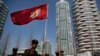 FILE - North Korean soldiers carry the Korean People's Army flag as they walk past residential buildings along Ryomyong street, in Pyongyang, North Korea, April 13, 2017.